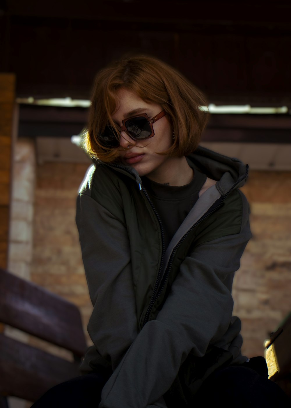 a woman sitting on a bench wearing sunglasses