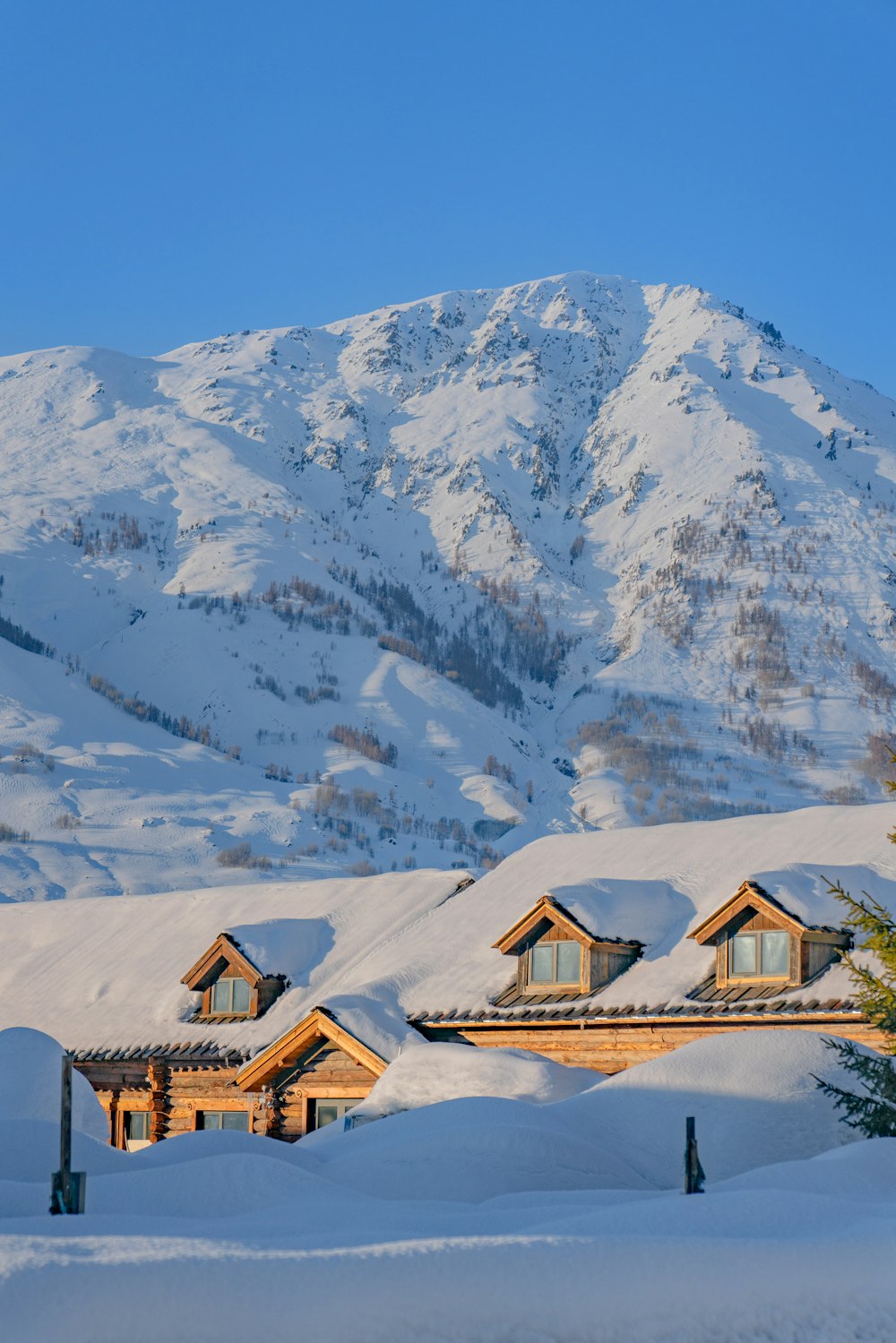 a snow covered mountain with a house in the foreground