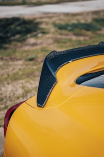 A dynamic shot of a carbon fiber rear spoiler mounted on a racing vehicle