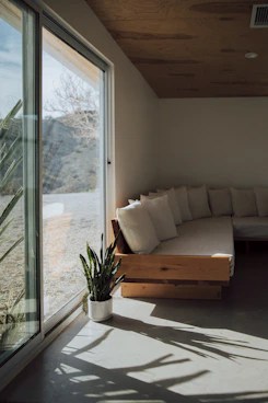 A cozy living room bathed in natural light showcasing minimalist furnishings and soothing earthy tones.