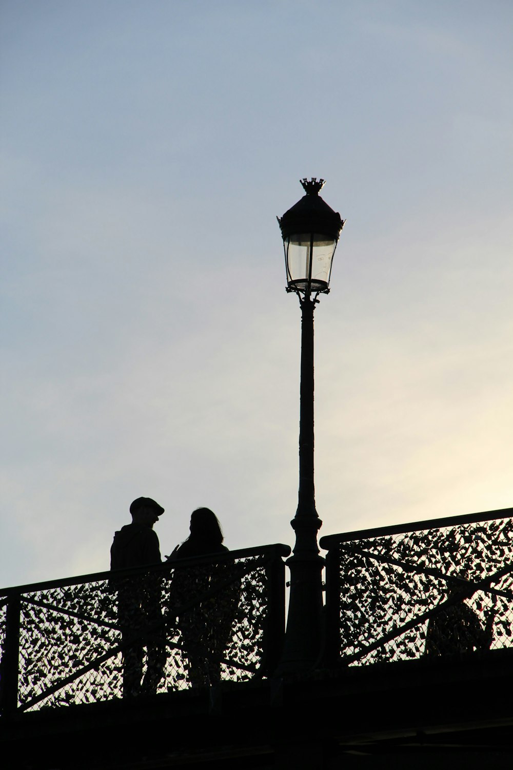 a couple of people standing on top of a bridge