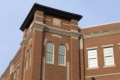A brick building with classical architectural features such as decorative cornices, arched windows, and a symmetrical design. The structure displays a mix of modern and traditional styles.