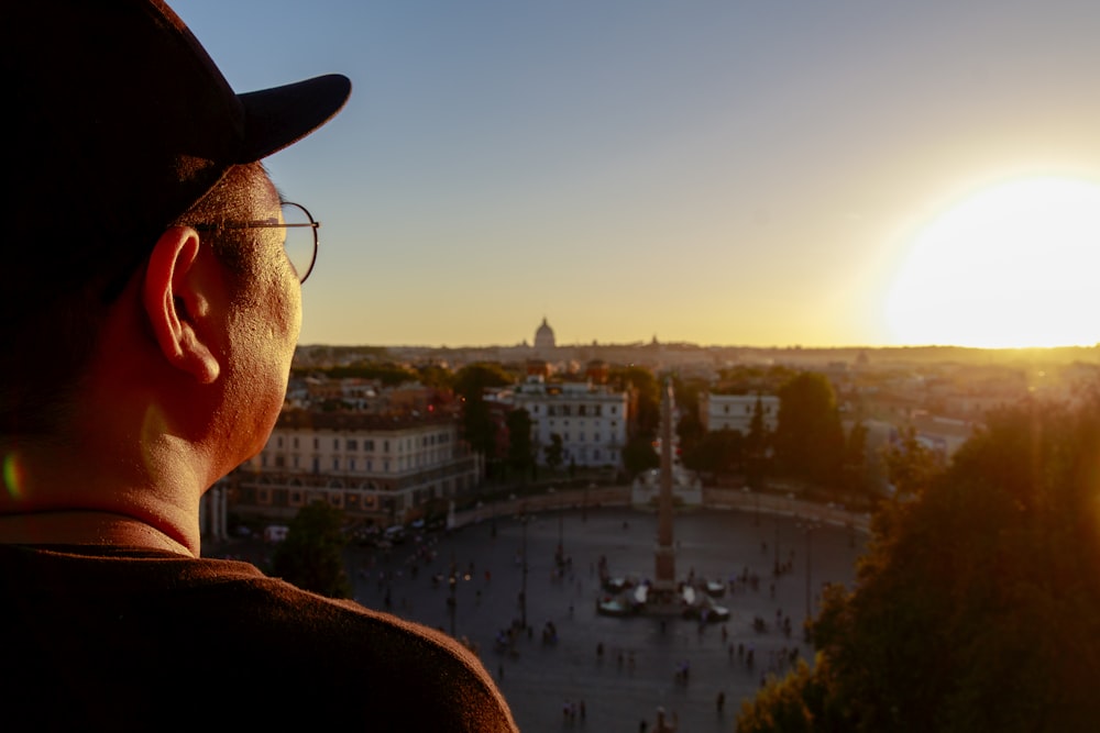 a man looking out over a city at sunset