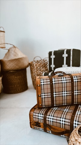 A collection of suitcases in various styles and colors arranged artistically against a neutral backdrop.