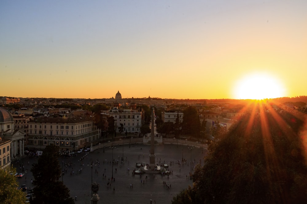 the sun is setting over a city square