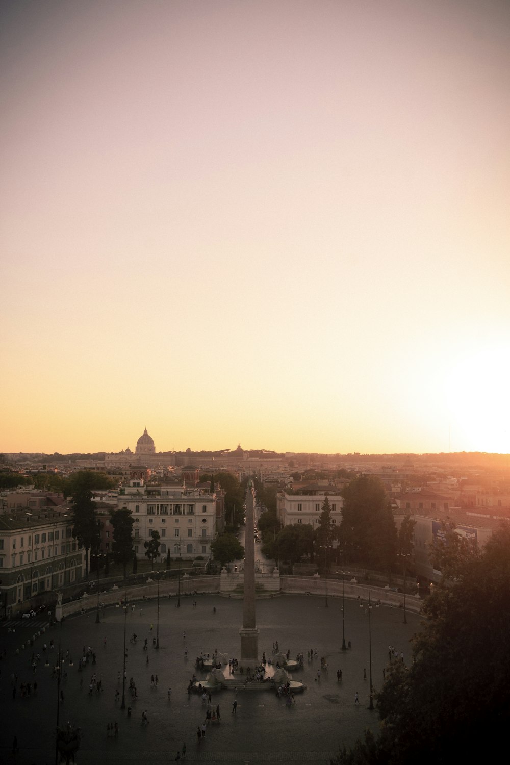 the sun is setting over a city square