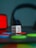 A white die with red dots is positioned on a surface surrounded by colorful circular tokens in red, blue, and green. In the background, there is a blurred set of headphones and a red rectangular object, creating a playful and colorful atmosphere.