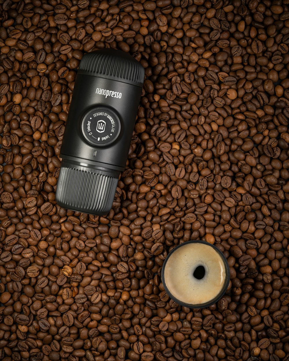 a coffee cup sitting on top of a pile of coffee beans