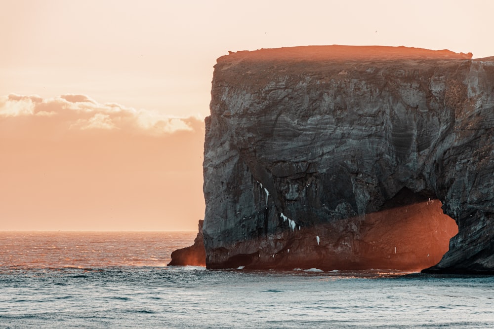 a large rock sticking out of the ocean