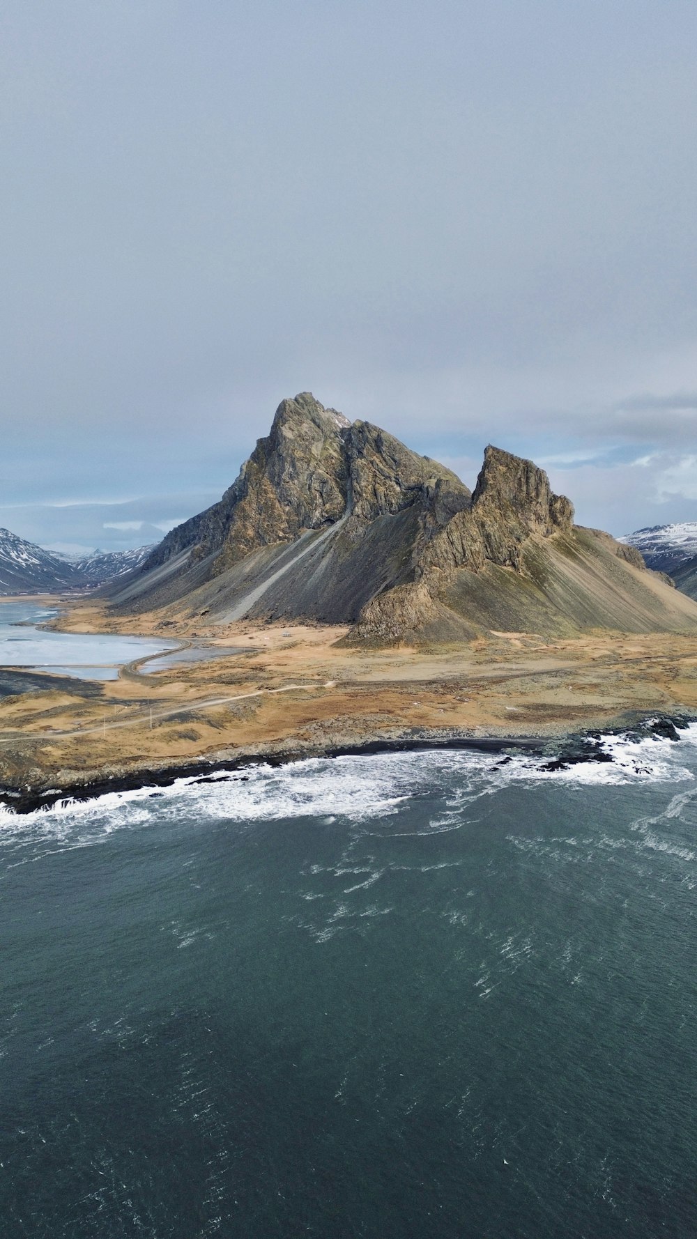 a large body of water with a mountain in the background