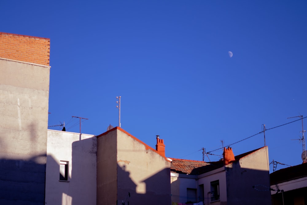 a clear blue sky with a half moon in the distance