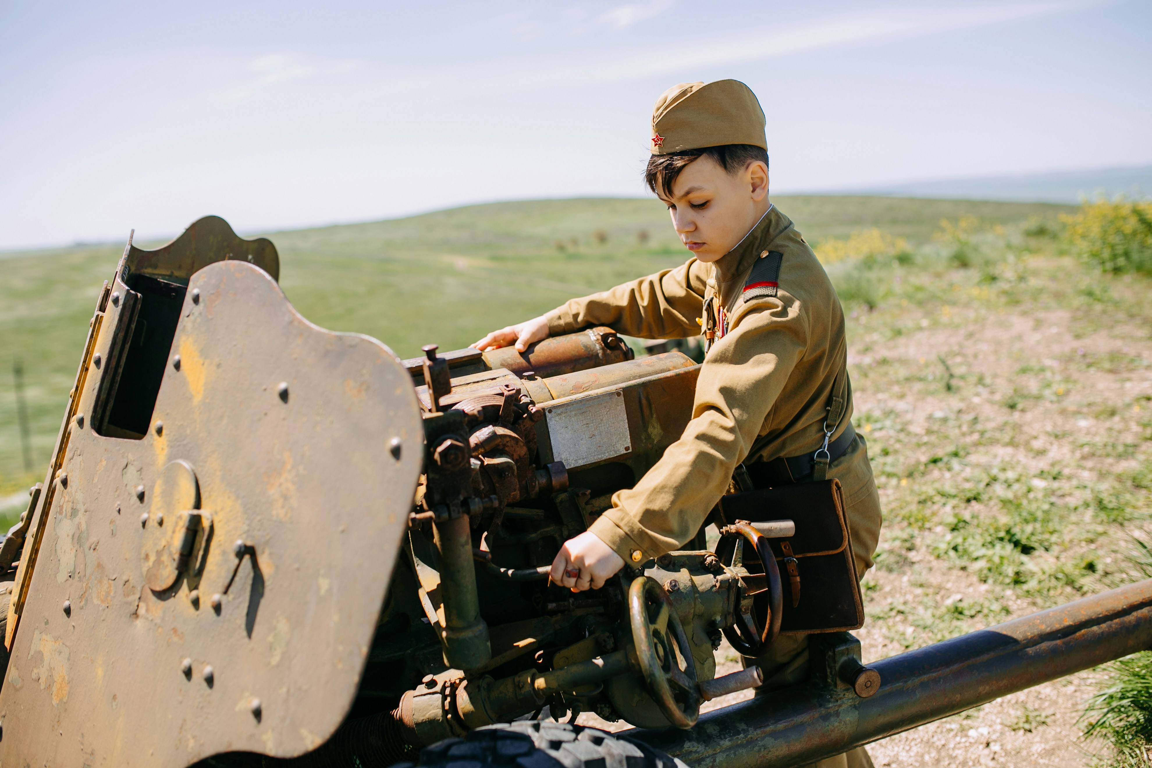 a boy in a military uniform working on a machine (Photo by Евгений Новиков on Unsplash)
