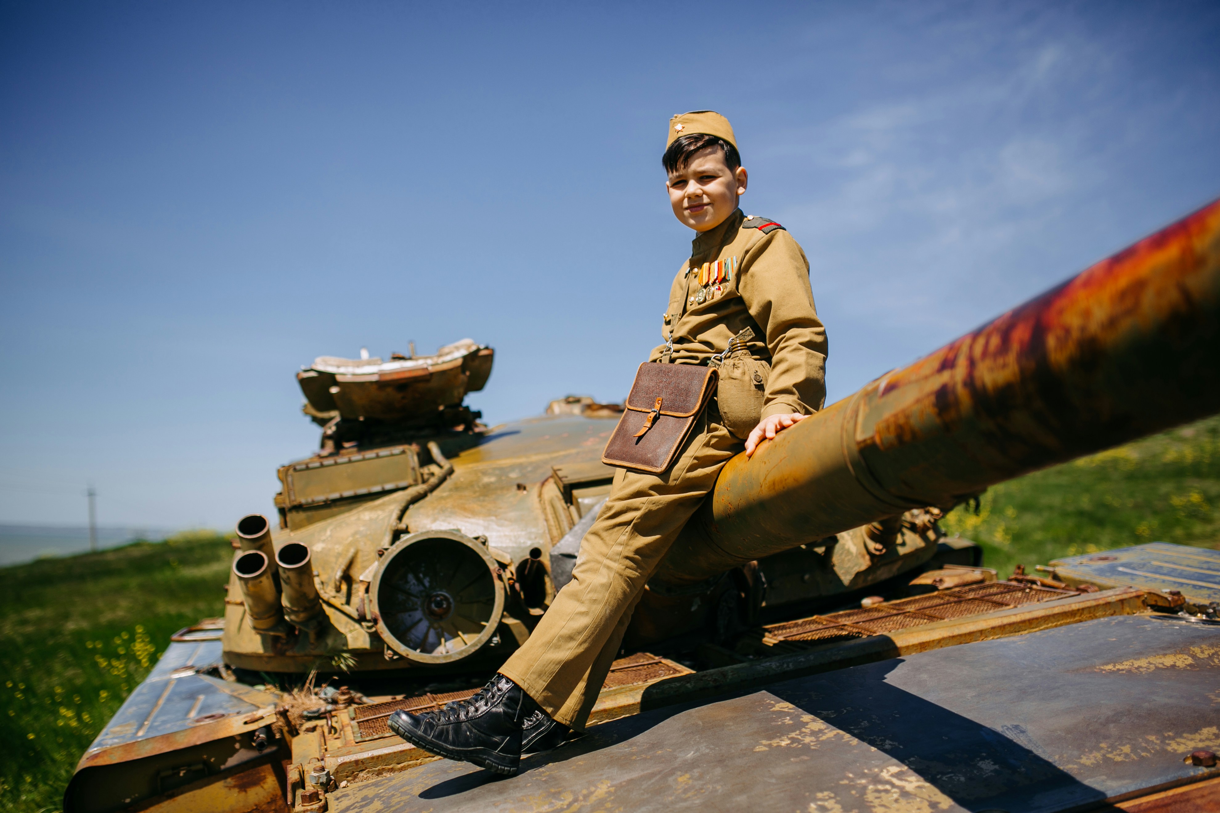 A man in uniform sitting on top of a tank photo – Free Military Image ...