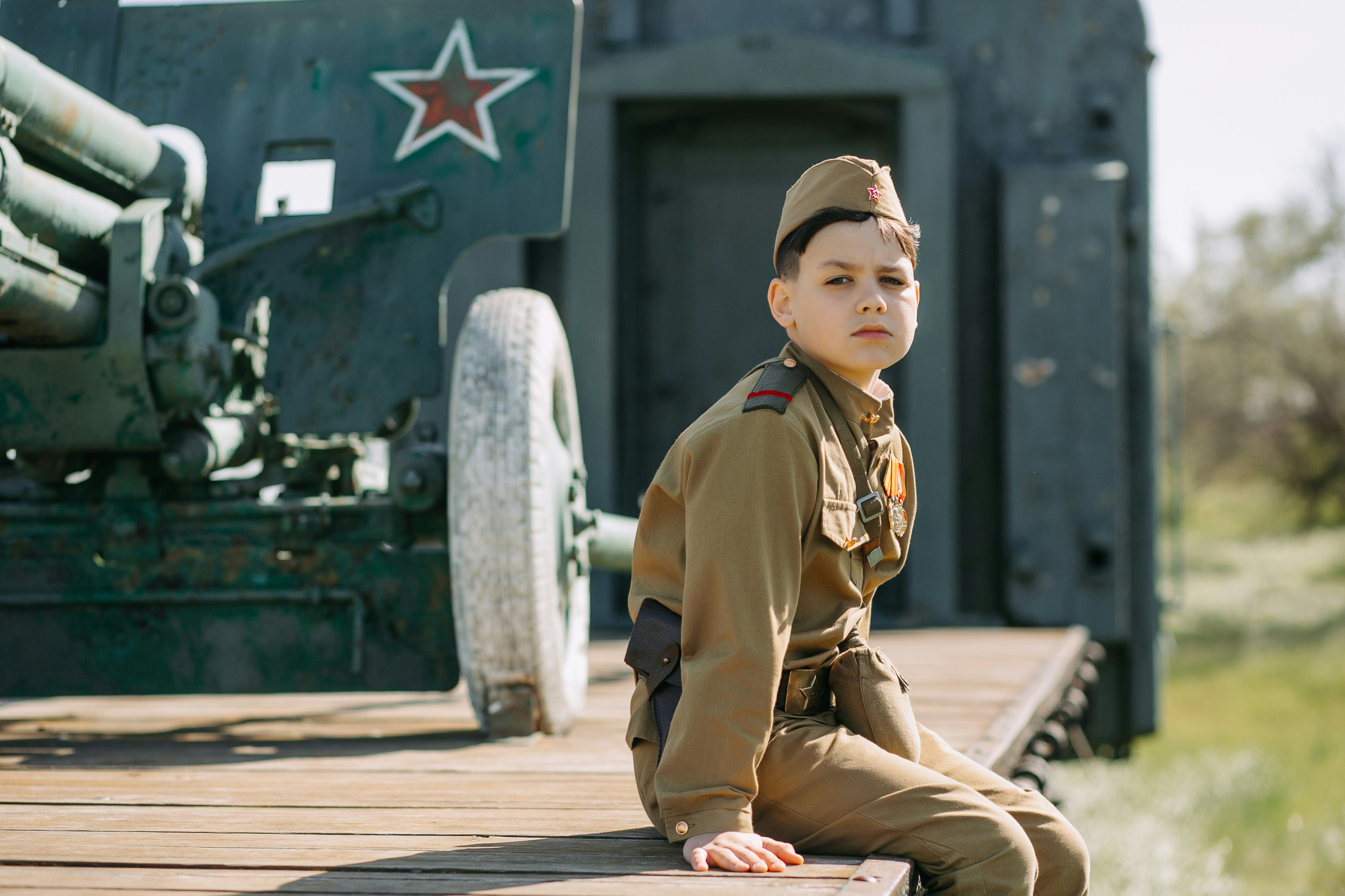 a young boy in a uniform sitting on a dock