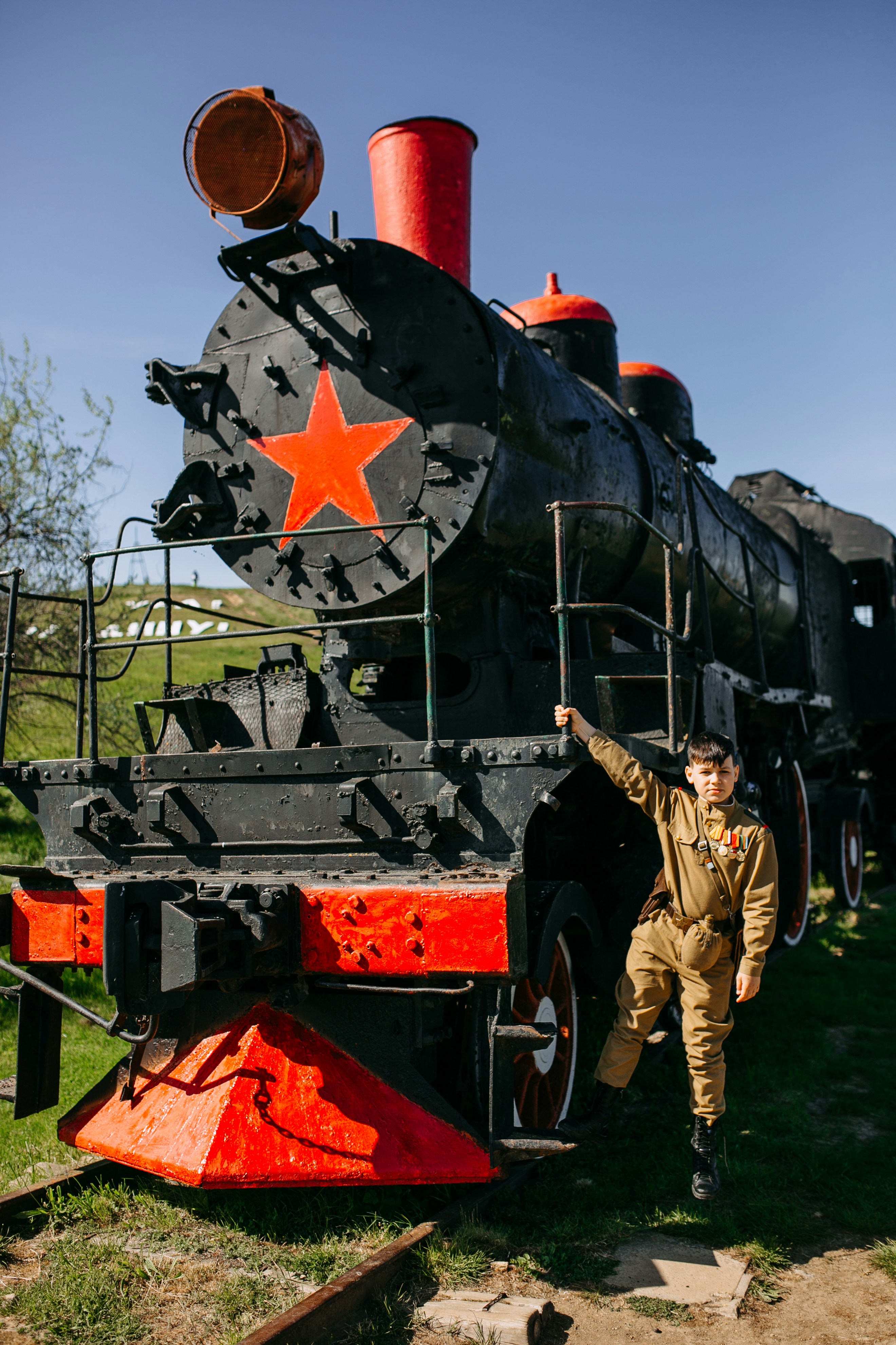 a man standing next to a black and red train
