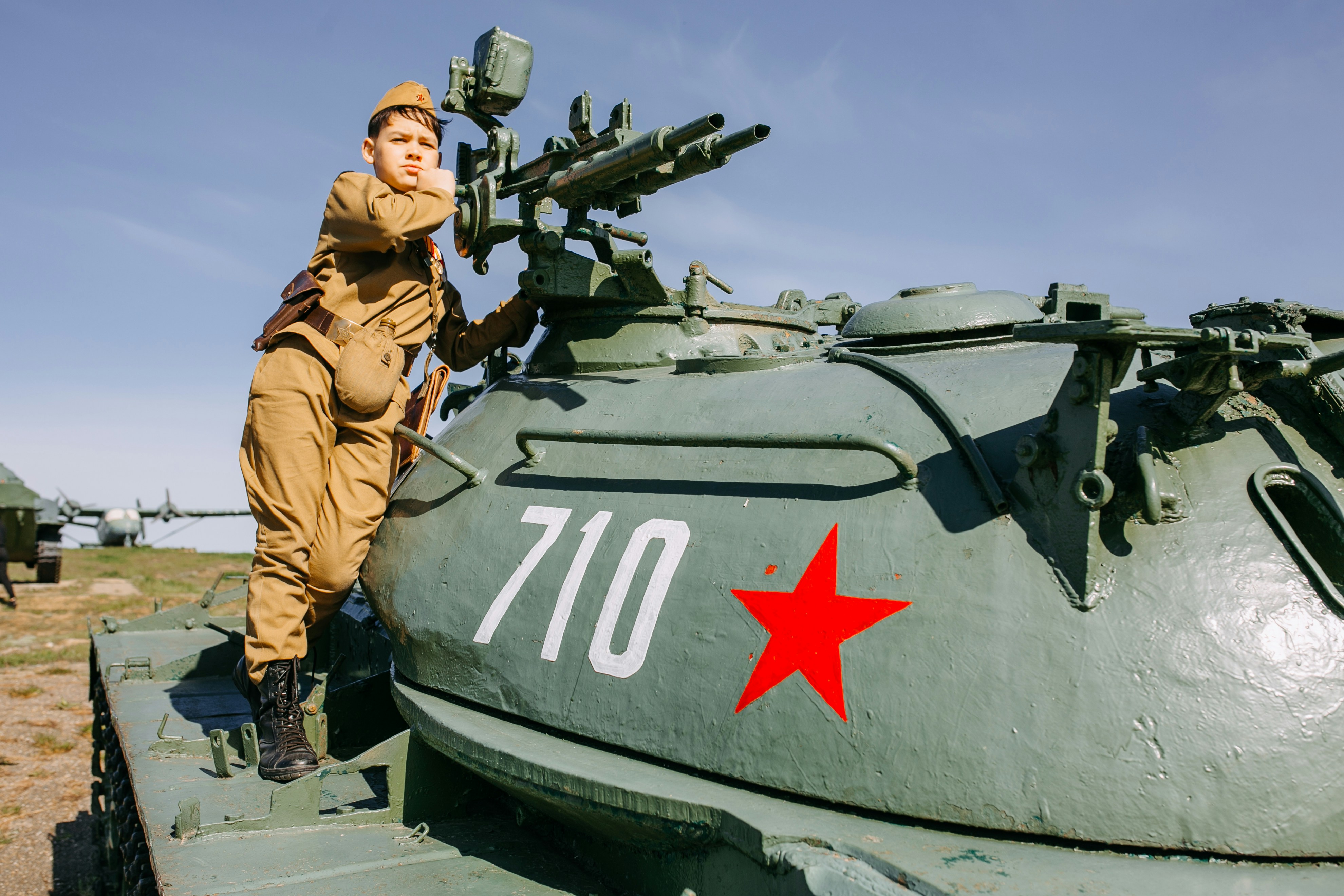 a woman in a military uniform standing on top of a tank