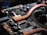 A close-up view of a circuit board featuring copper heat pipes, various electronic components, connectors, and chips. The copper elements stand out against the dark, intricate background of the circuit board.