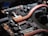A close-up view of a circuit board featuring copper heat pipes, various electronic components, connectors, and chips. The copper elements stand out against the dark, intricate background of the circuit board.