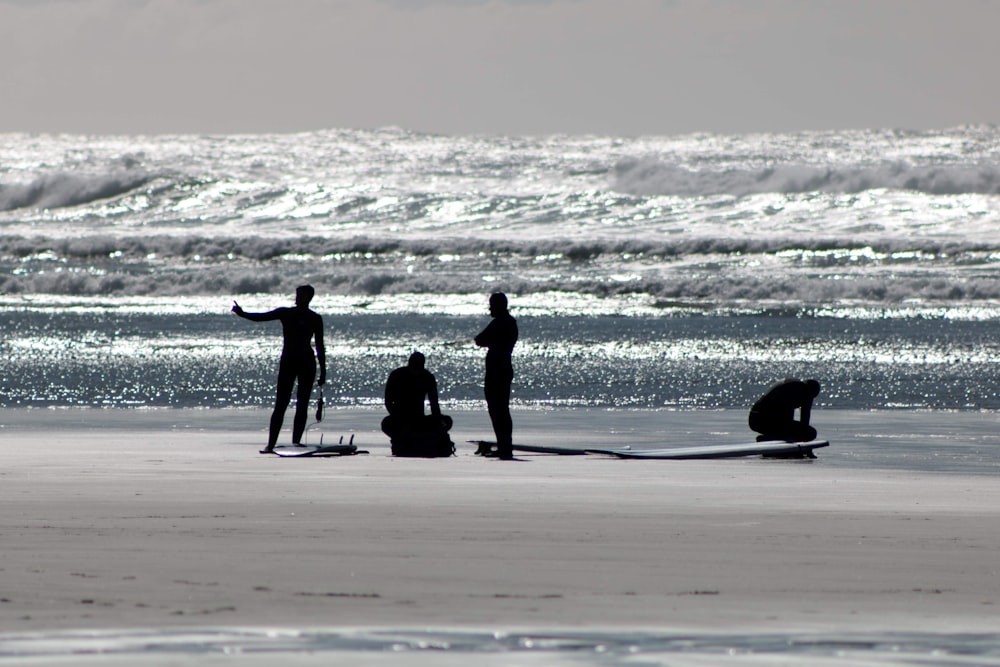 a group of people standing on top of a beach