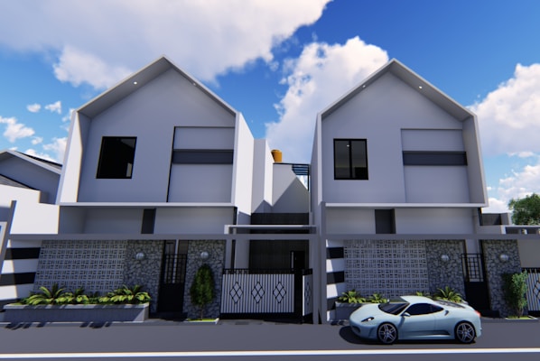 Two modern, symmetrical, double-story houses with minimalistic architectural features. The houses have white walls with dark windows and a geometric patterned facade at the front. A sleek sports car is parked on the street in front of the house. The sky is blue with scattered clouds.