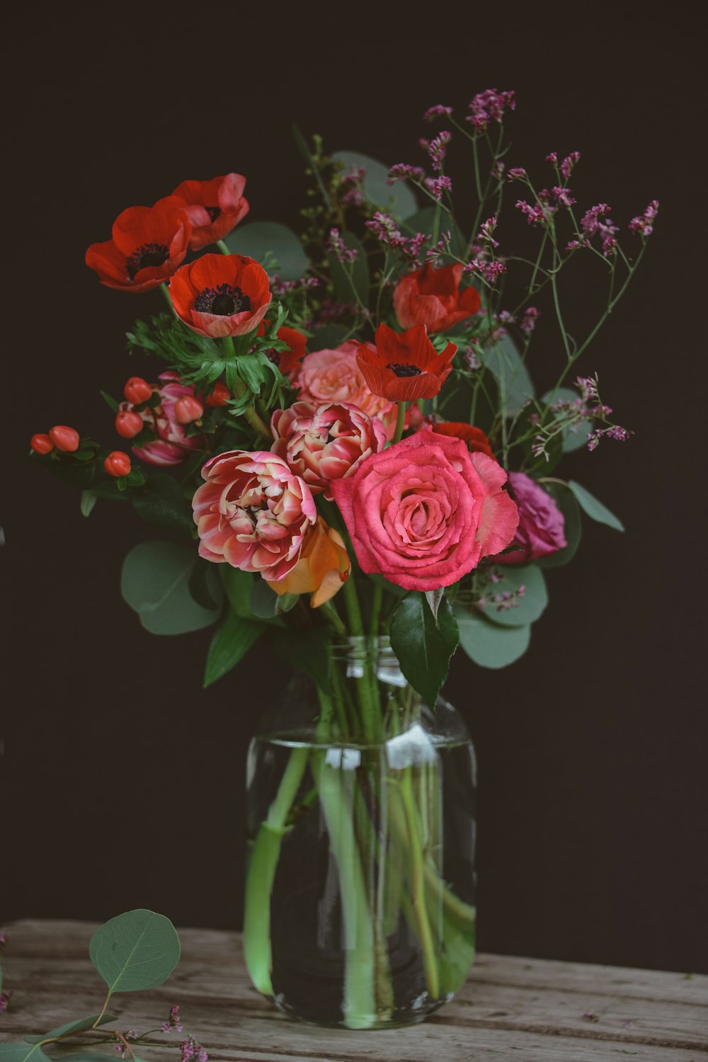 a vase filled with lots of flowers on top of a table