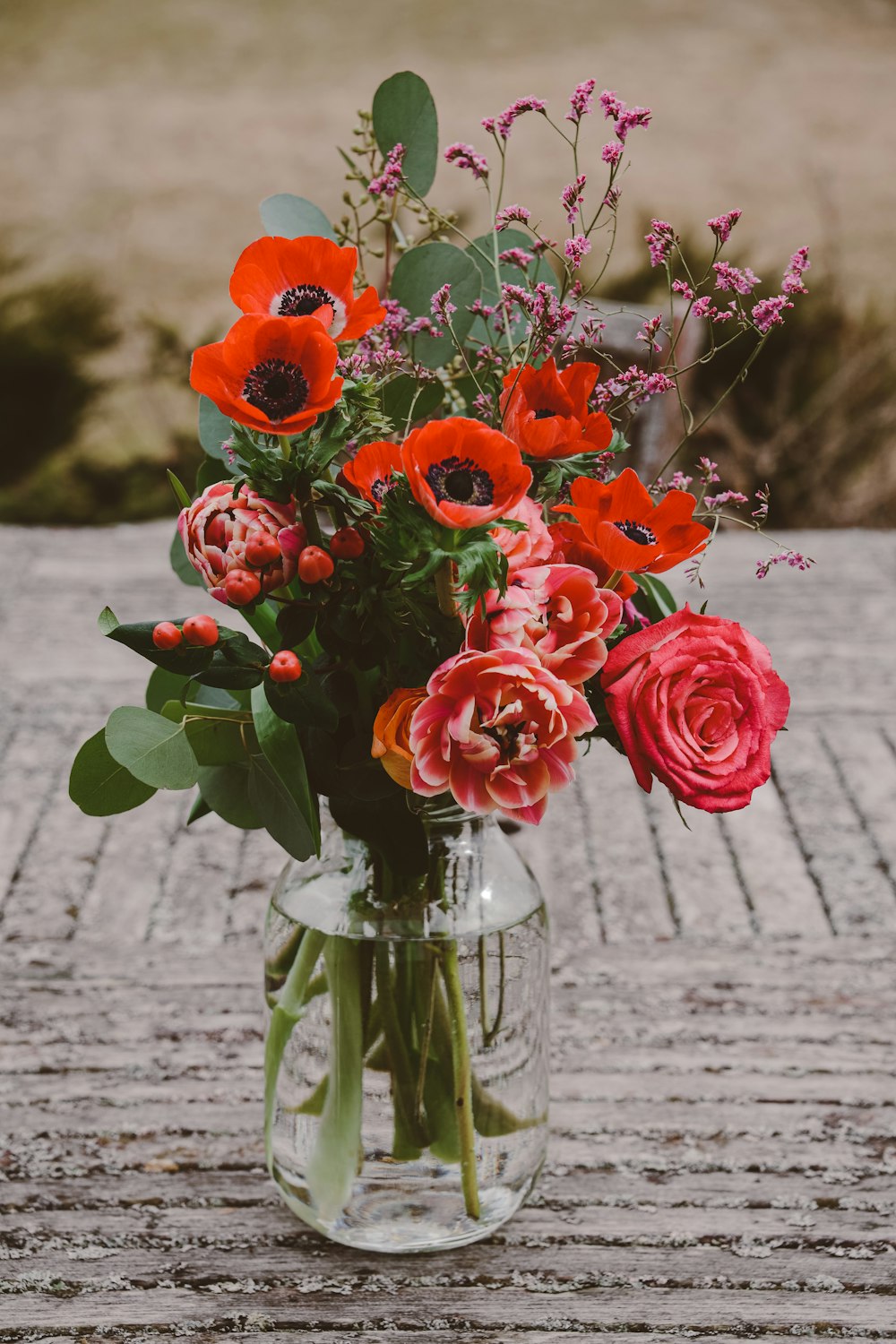 a vase filled with lots of flowers on top of a table