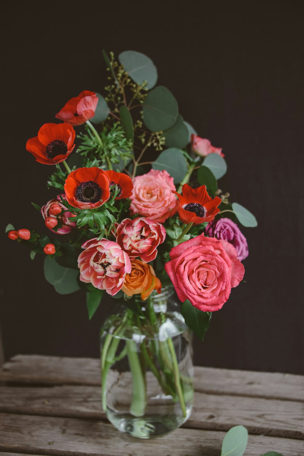 a vase filled with lots of different colored flowers