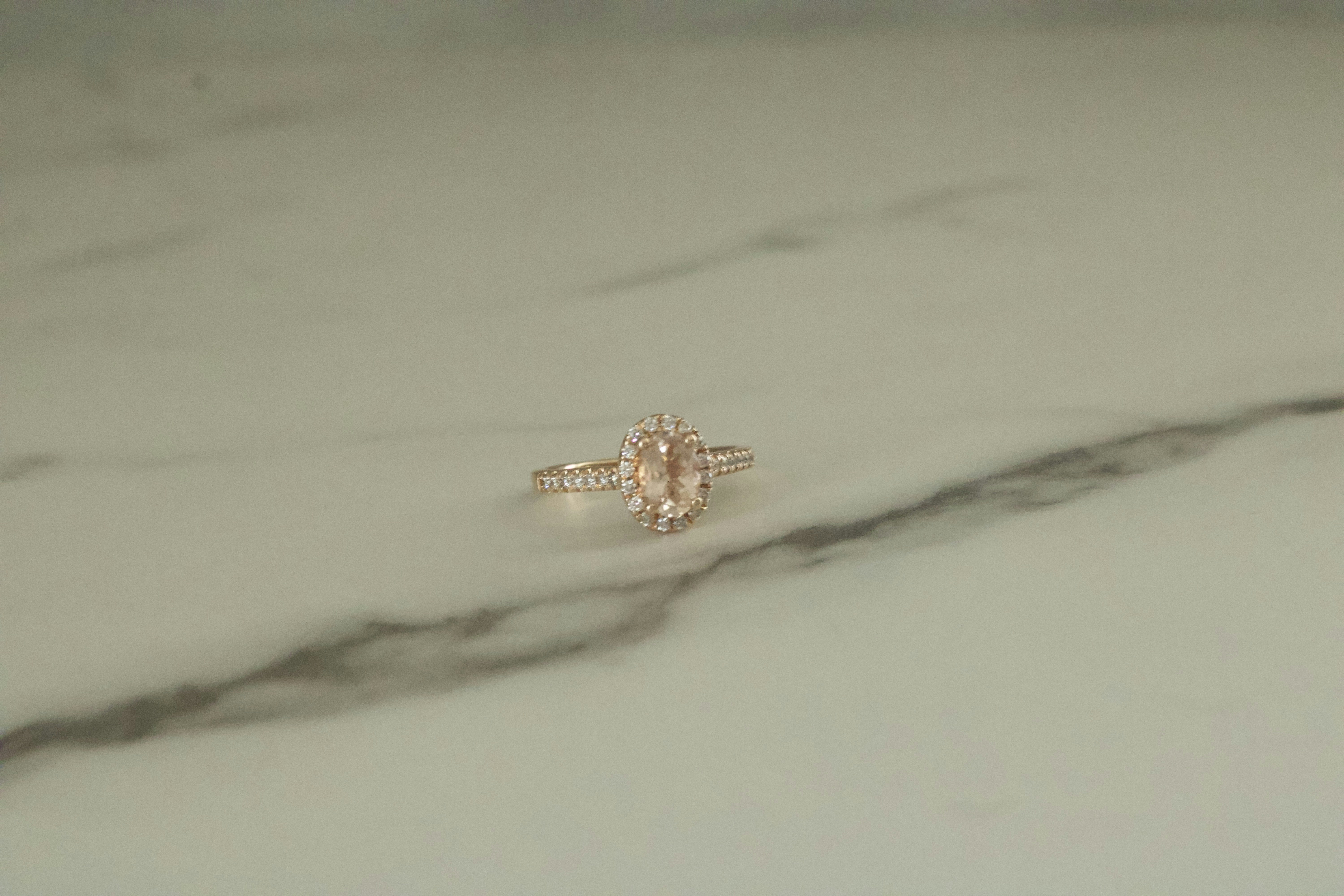 Solitaire diamond engagement ring on white marble surface
