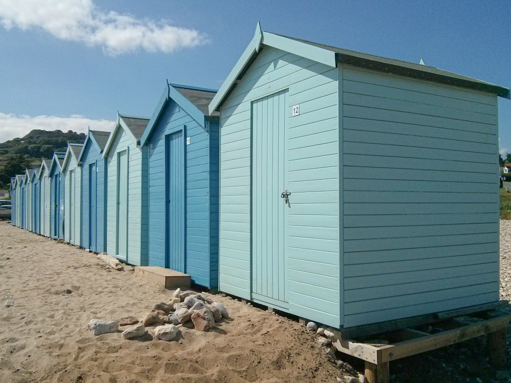 a row of beach huts sitting on top of a sandy beach