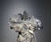 A mannequin is adorned with an elaborate and intricate dress featuring voluminous floral decorations and ribbons. The design includes shimmering elements and textured layers, creating a luxurious and artistic appearance.