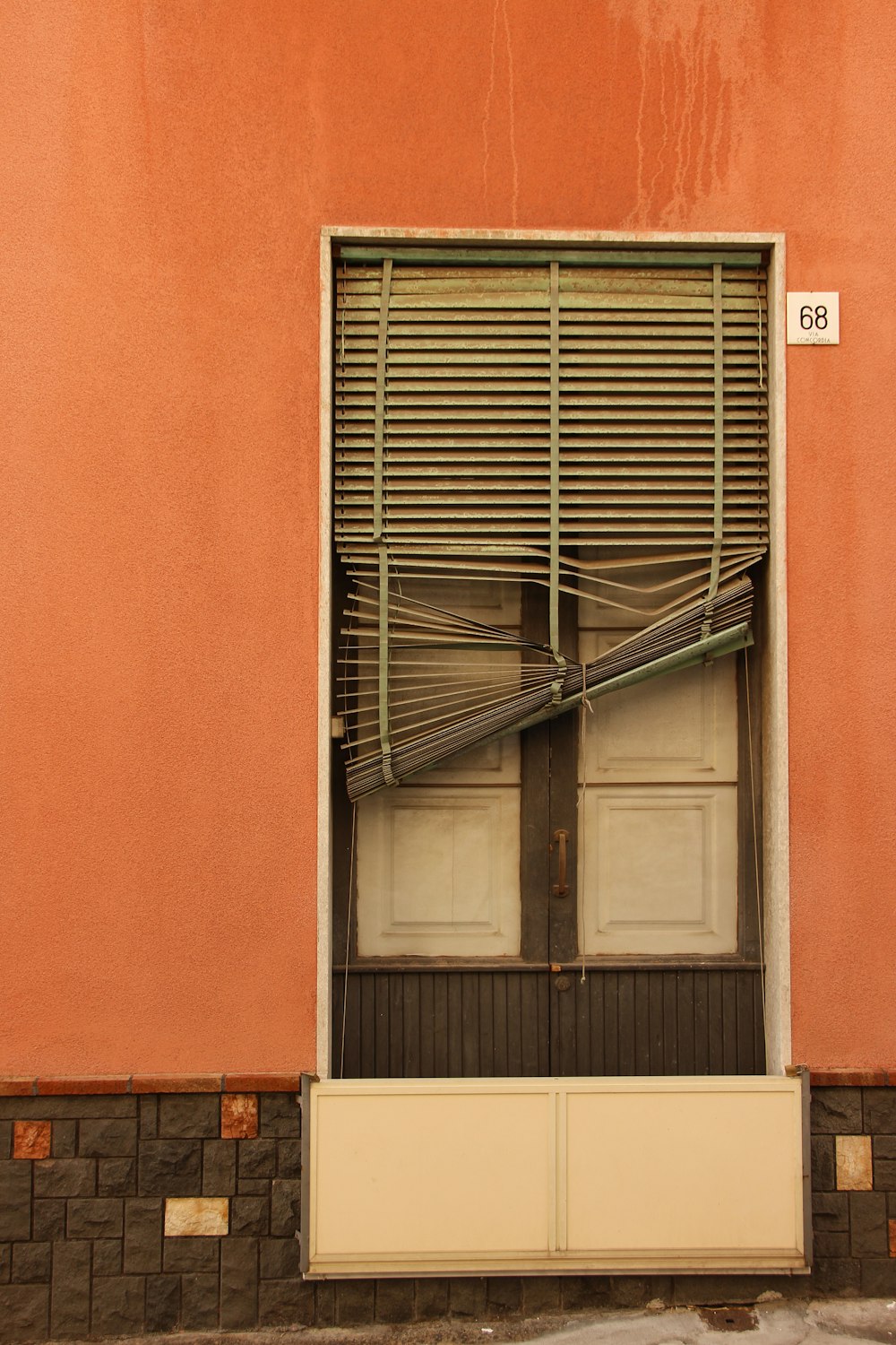 a building with a closed window and a street sign