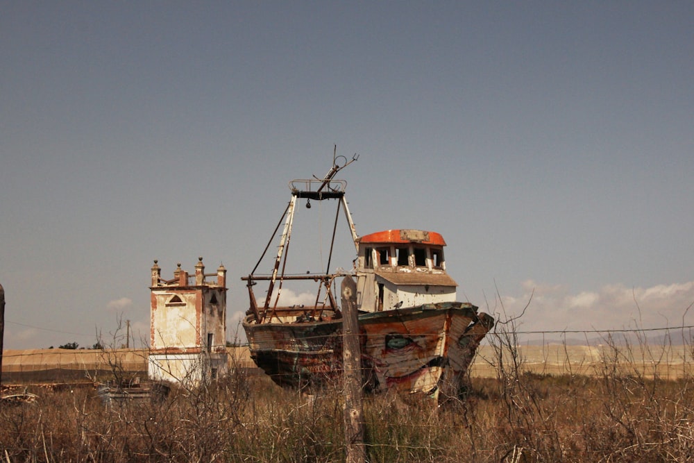 an old boat sitting in the middle of a field
