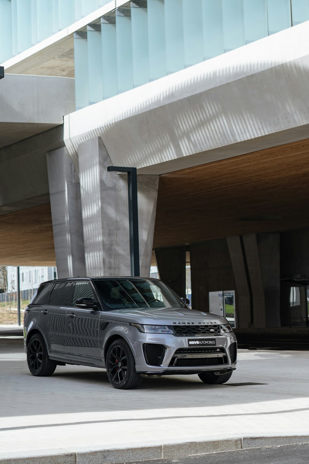 a silver range rover parked in front of a building