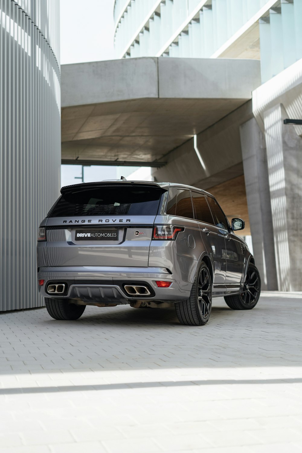 a grey range rover parked in front of a building