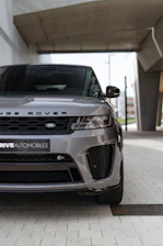 Sleek black Range Rover parked at an airport terminal under soft evening lights.