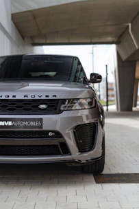 Sleek black Range Rover parked at an airport terminal under soft evening lights.