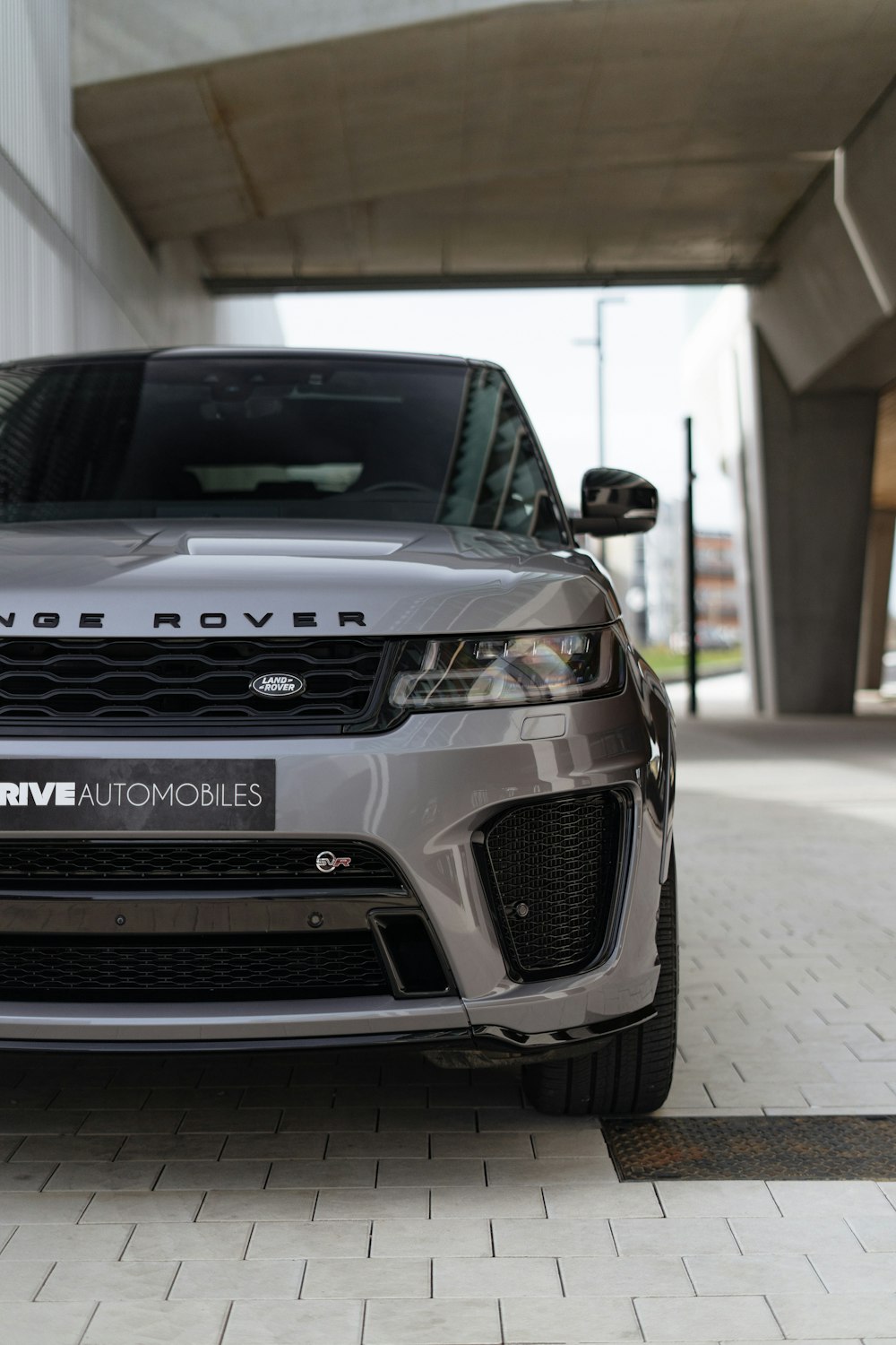 a silver range rover parked in front of a building