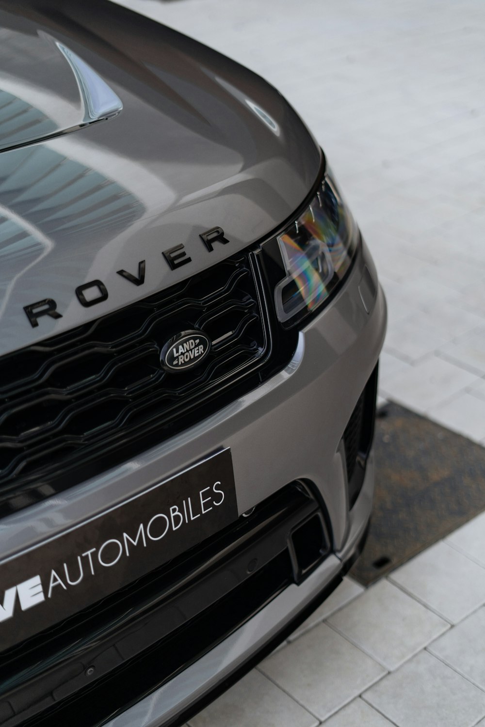 the front of a grey range rover parked on a sidewalk