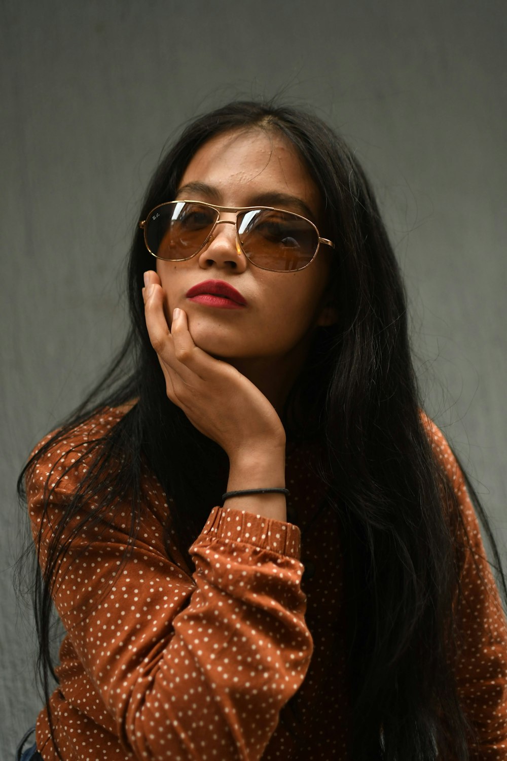 a woman in a polka dot shirt and sunglasses