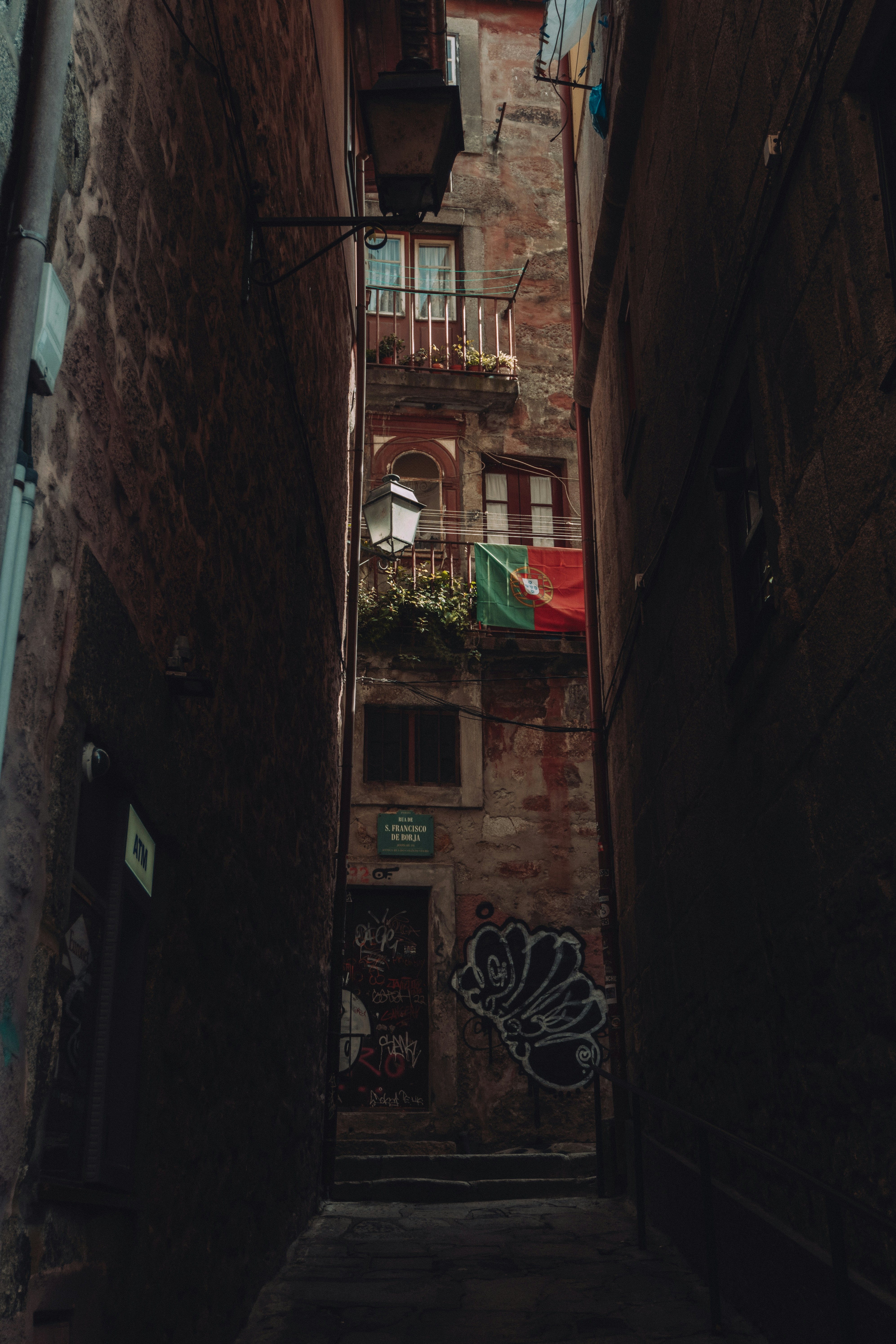 a narrow alleyway with graffiti on the walls