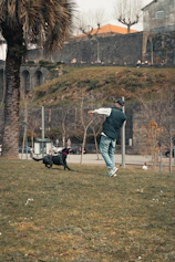 a man playing frisbee with his dog in a park