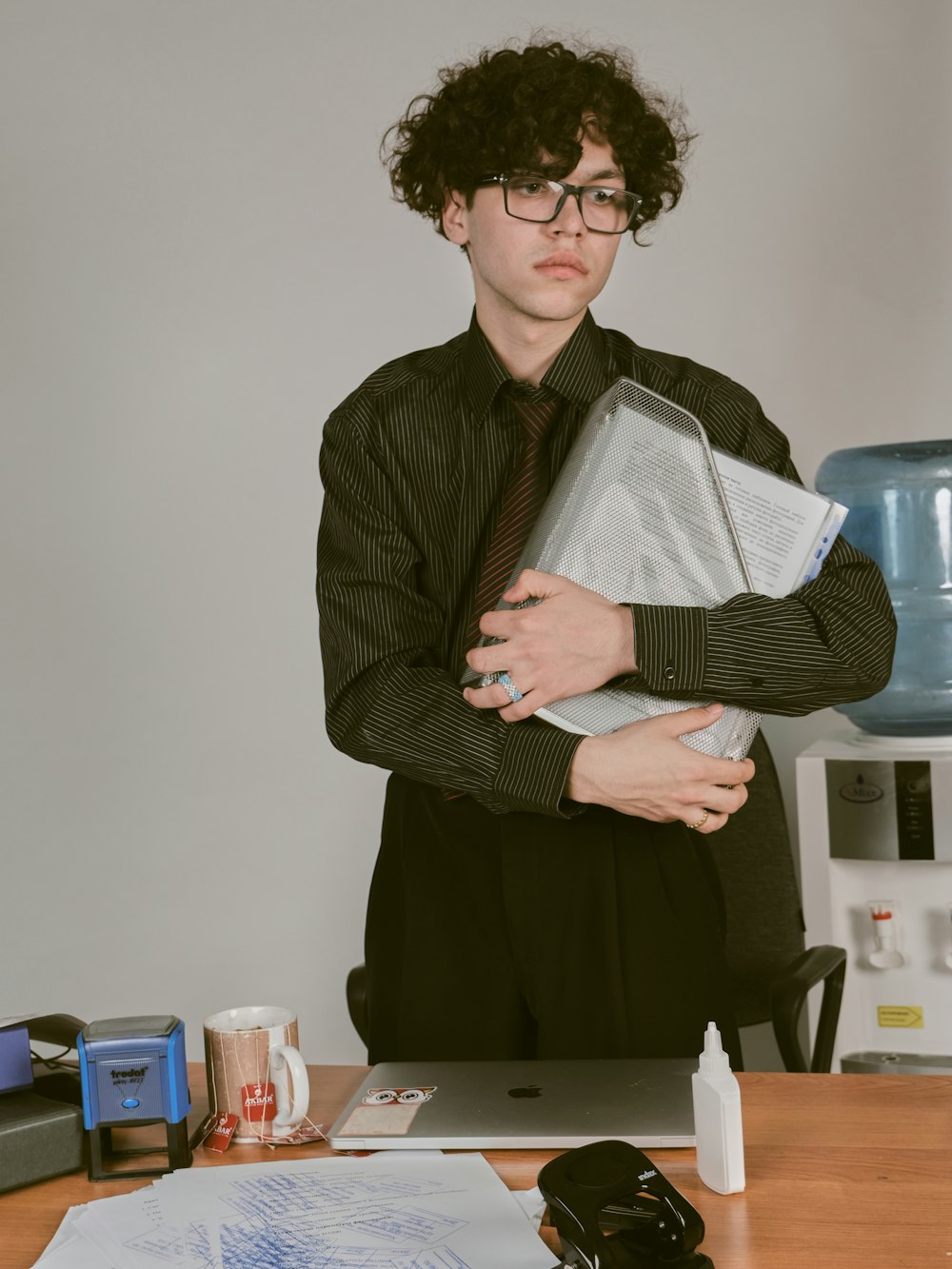 a woman in a black shirt and tie holding a binder