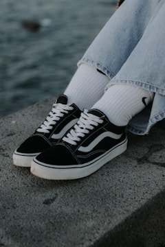 Casual sneakers styled with jeans on a wooden bench