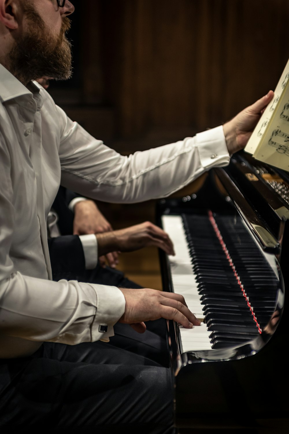 a man sitting at a piano playing a musical instrument