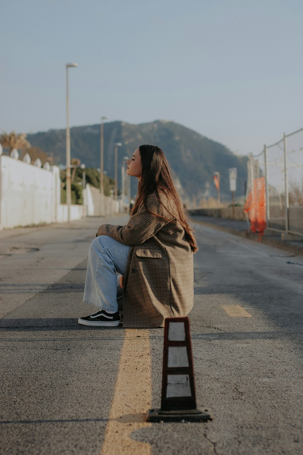 a woman sitting on the side of a road