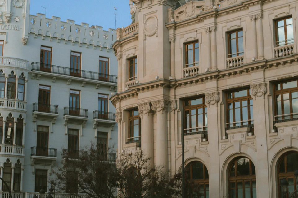 Two-story building with white facade and brown accents stands at a street corner location