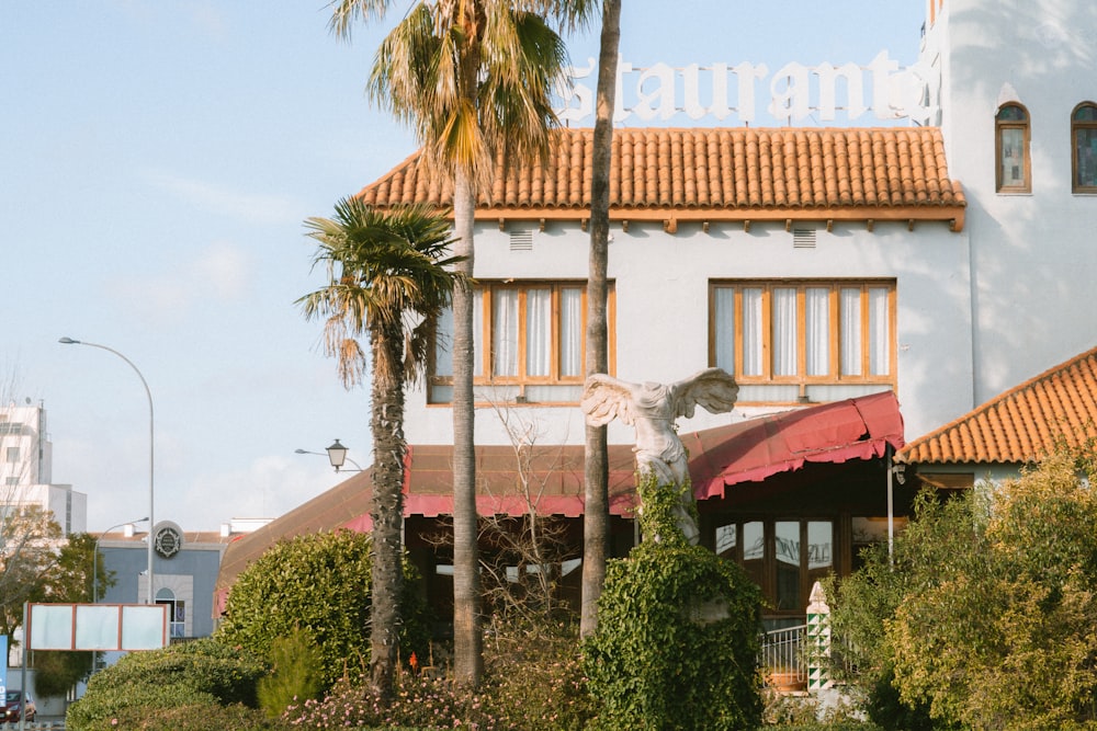 a white building with a red awning and palm trees