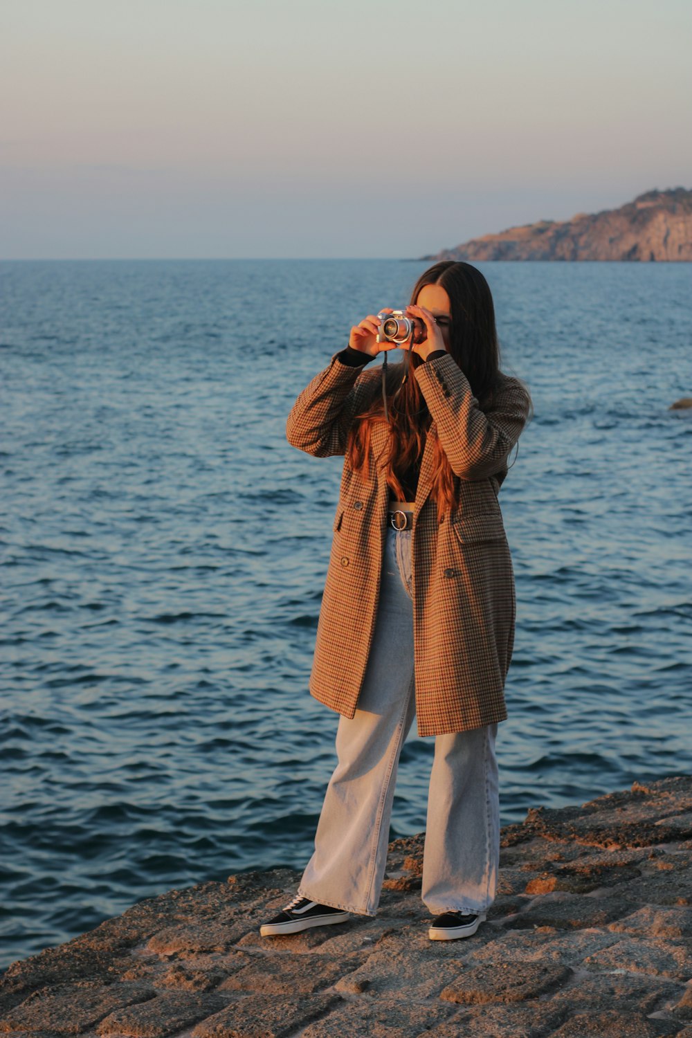 a woman taking a picture of the water