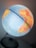 A close-up view of a globe showing parts of the Atlantic Ocean, Africa, and South America with various countries marked in different colors. The globe is mounted on a stand and has a soft light illuminating it, suggesting a warm and inviting atmosphere.