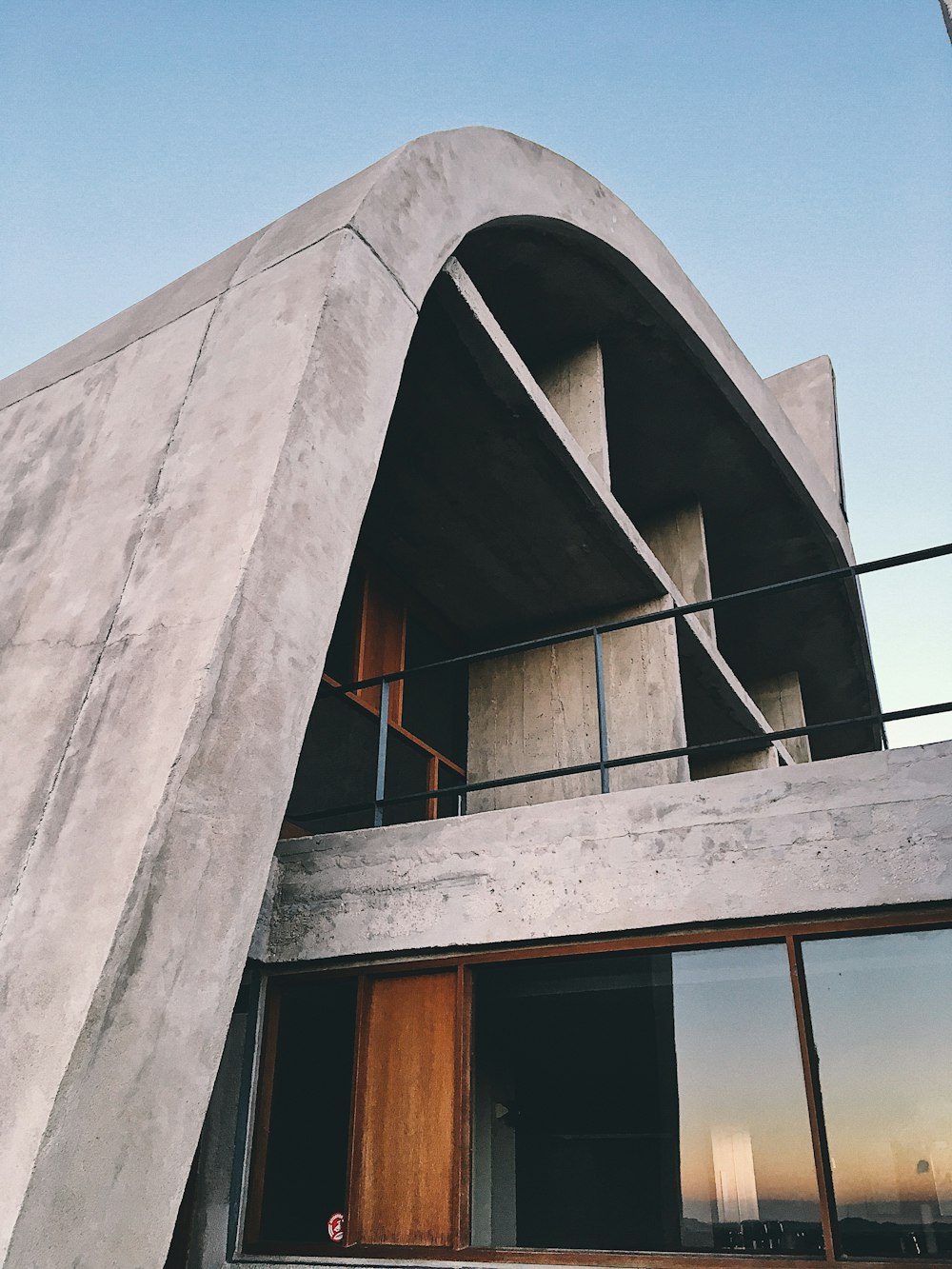 a concrete building with a wooden door and balcony